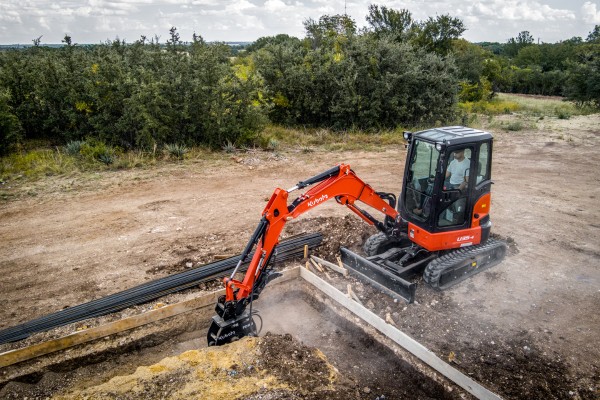 Kubota mini excavator digging on a rental jobsite